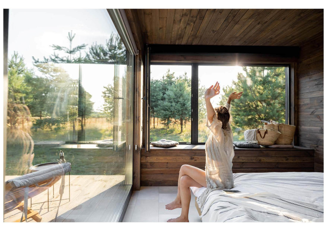 Women stretches after good night sleep, bed facing outdoors
