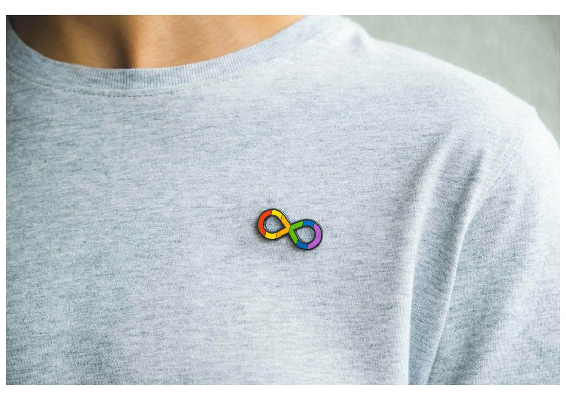 Rainbow infinity symbol pin on T-shirt representing Neurodiversity
