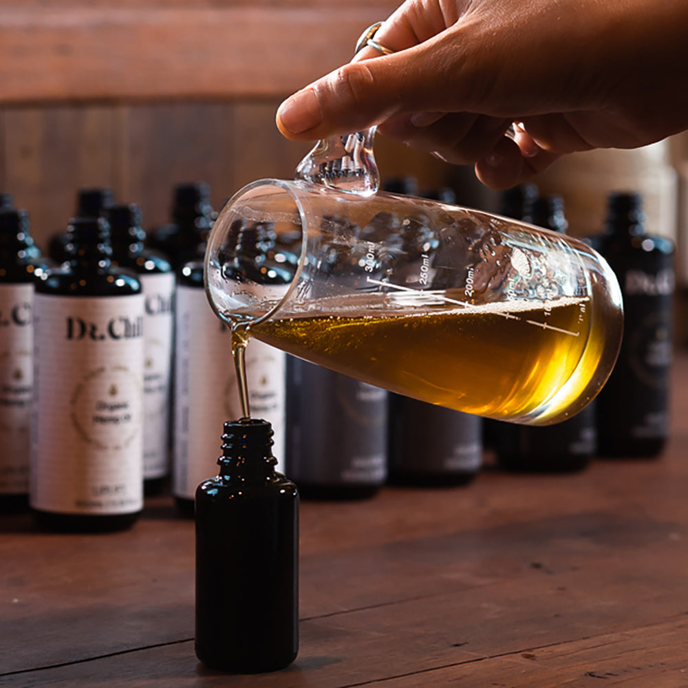 Hemp body oil being hand poured into bottle