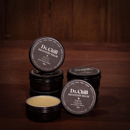 Dr. Chill Recovery Balm containers on a wooden surface