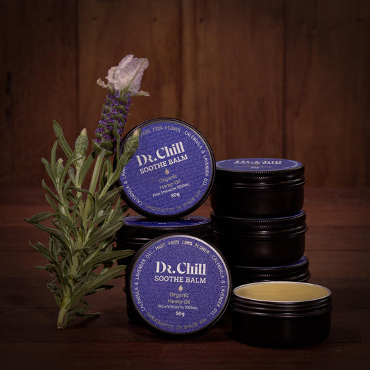 Dr. Chill soothe balm containers with lavender flowers and leaves on a wooden background